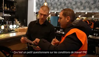 un salarié d'un restaurant reçoit de l'information par un militant CFDT à Paris