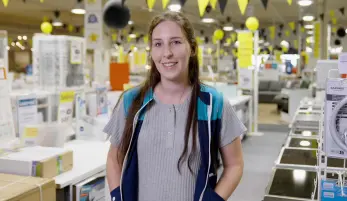 travailleuse dans un magasin BUT au milieu des appareils d'électroménager